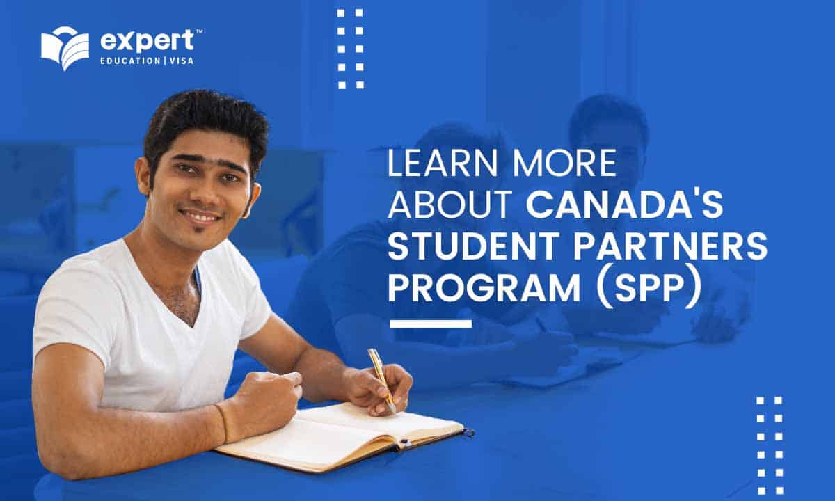 sitting student smiling in the exam hall while writing on the test paper