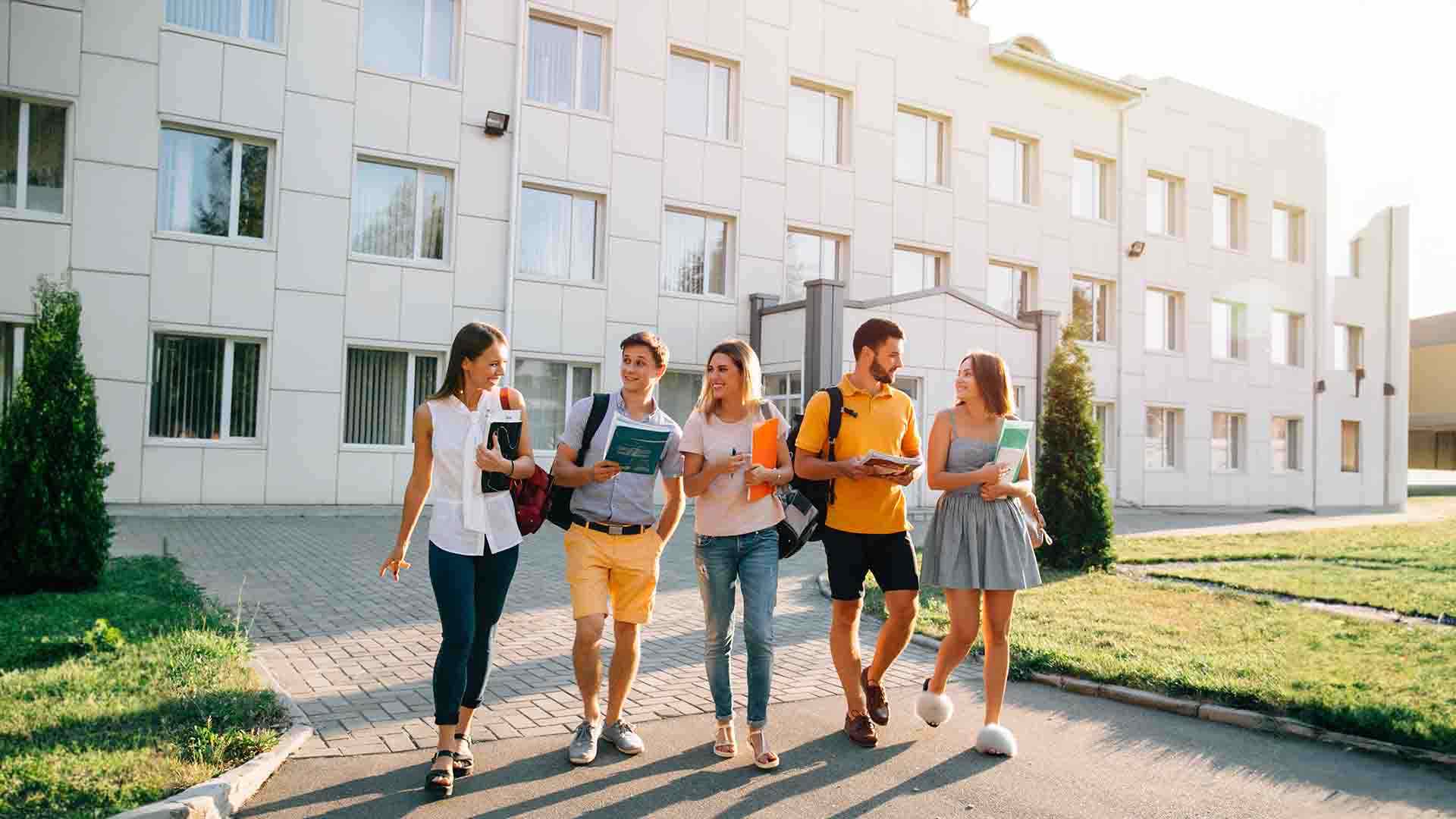 Students with books walking on the university campus