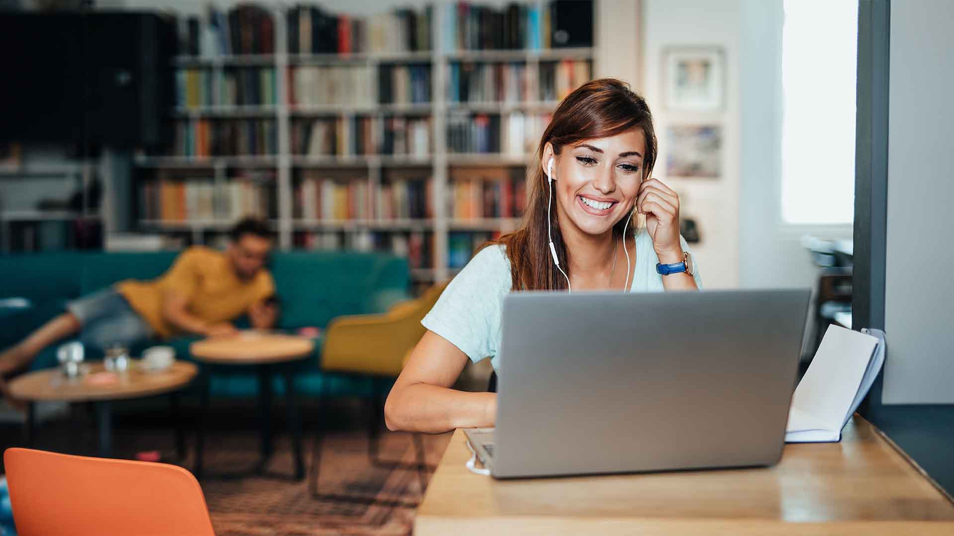 smiling student with headphones and laptop